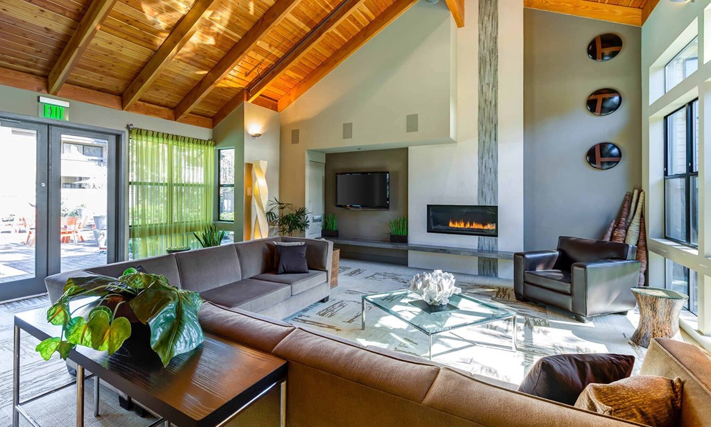 a large living room with a large leather couch and a glass coffee table a large living room with a large leather couch and a glass coffee table at The Lakes Apartments, Bellevue, 98007
